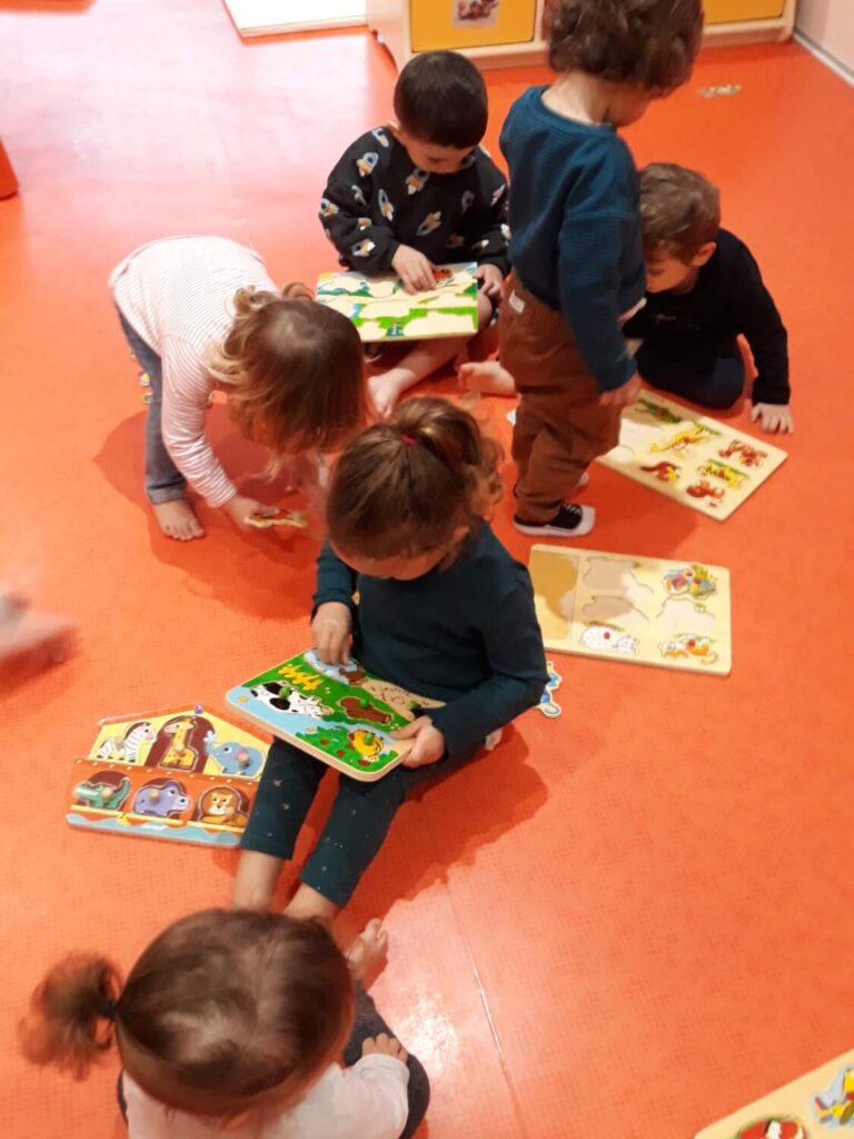 PHOTO DES ENFANTS DE LA CRÈCHE DES MINIS ENTRAIN DE FAIRE UNE ACTIVITÉ MANUELLE AVEC DES JEUX EN BOIS