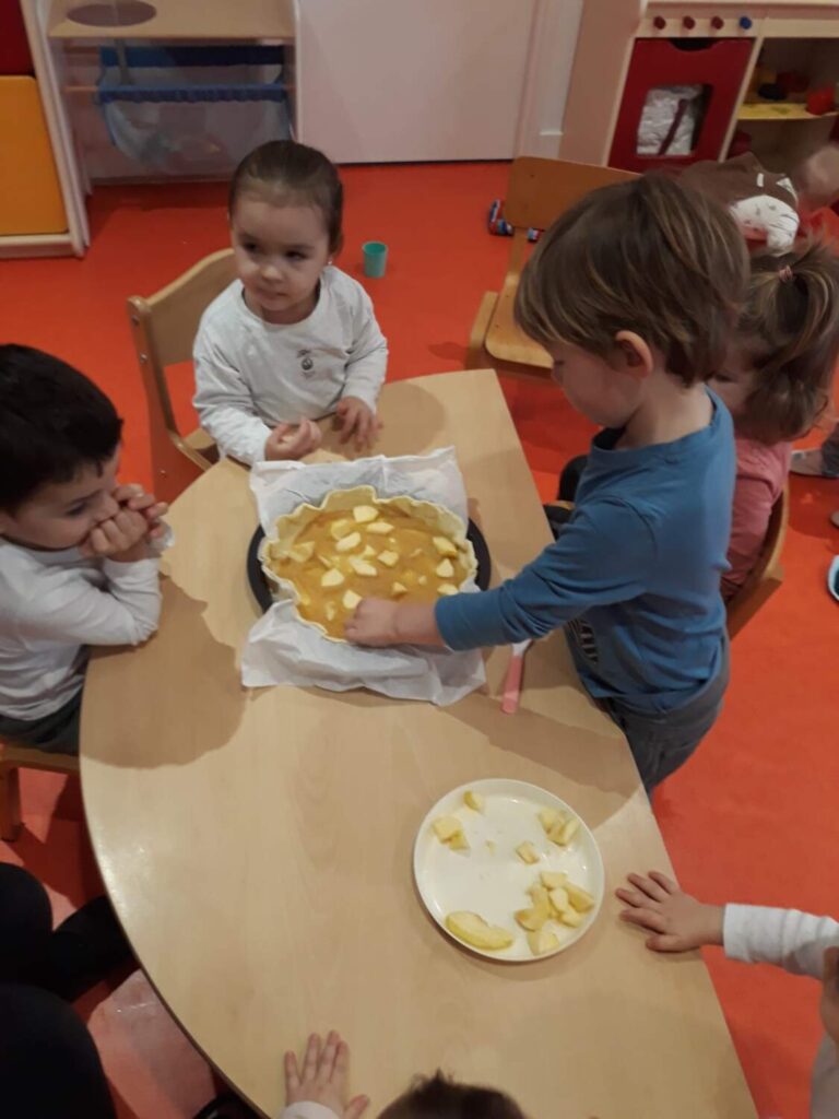 PHOTO DES ENFANTS DE LA CRÈCHE DES MINIS ENTRAIN DE PRÉPARER UNE GALETTE DES ROIS AVEC DE LA POMME