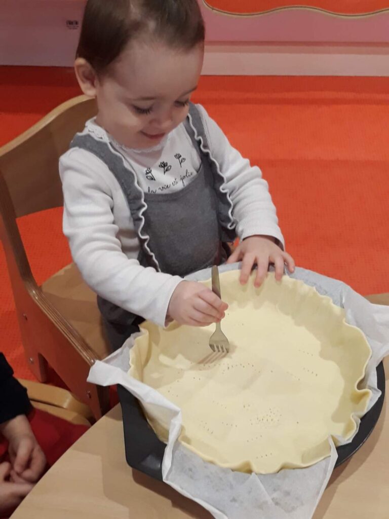 PHOTO DES ENFANTS DE LA CRÈCHE DES MINIS ENTRAIN DE PRÉPARER UNE GALETTE DES ROIS