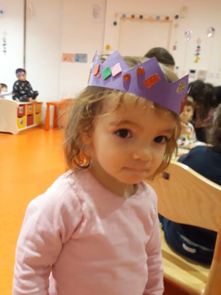 PHOTO D'UNE PETITE FILLE AVEC UNE COURONNE EN PAPIER SUR LA TÊTE