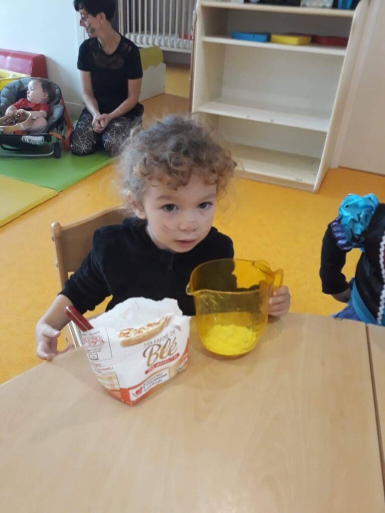 PHOTO D'UNE FILLETTE ENTRAIN DE PRÉPARER UN GÂTEAU POUR HALLOWEEN