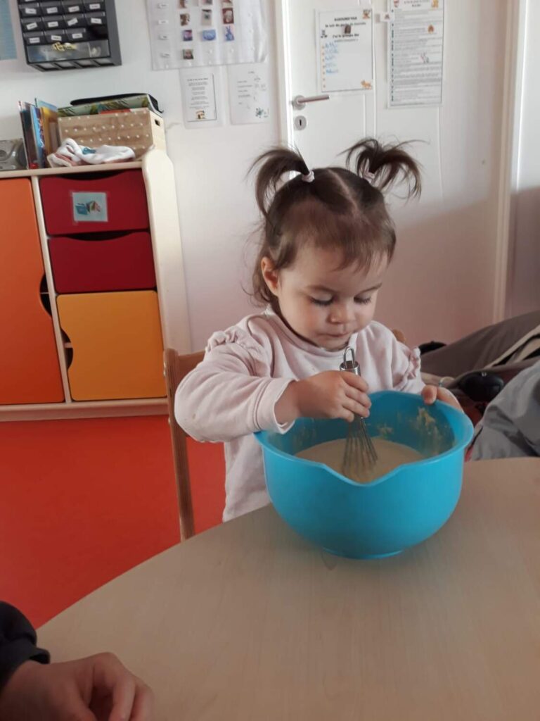 PHHOTO D'UNE PETITE FILLE ENTRAIN DE FAIRE UNE PÂTE À CRÊPES