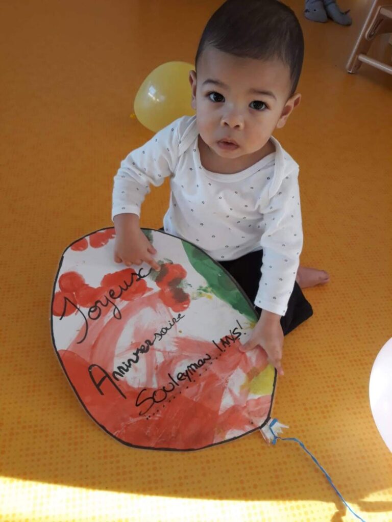 PHOTO D'UN PETIT GARÇON AVEC UNE PANCARTE EN FORME DE BALLON