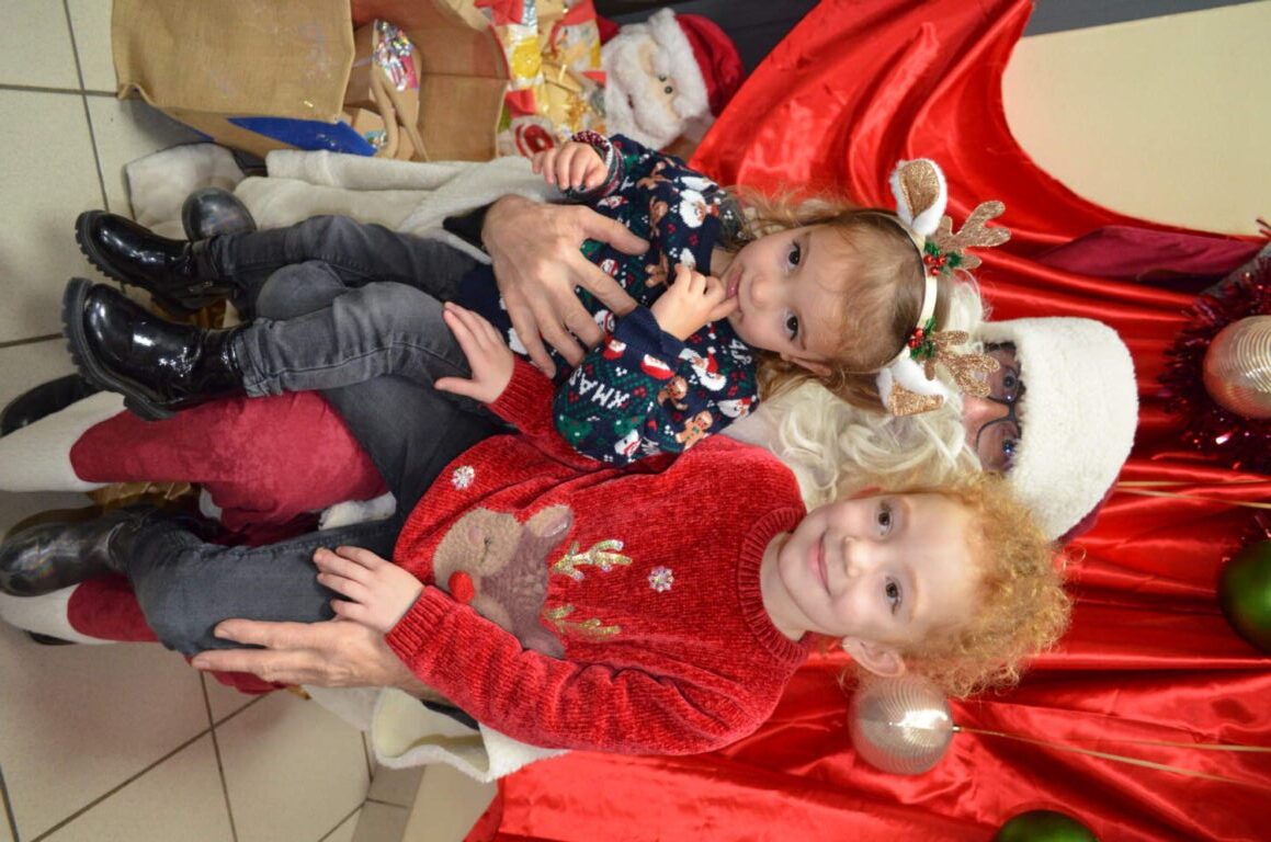 PHOTO D'UN MONSIEUR DÉGUISÉ EN PÈRE NOËL VEC UN ENFANT DE LA CRÈCHE DES MINIS