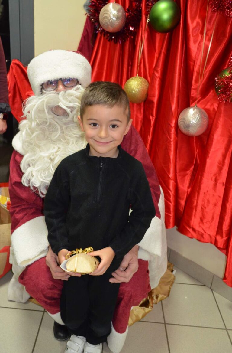 PHOTO D'UN MONSIEUR DÉGUISÉ EN PÈRE NOËL VEC UN ENFANT DE LA CRÈCHE DES MINIS