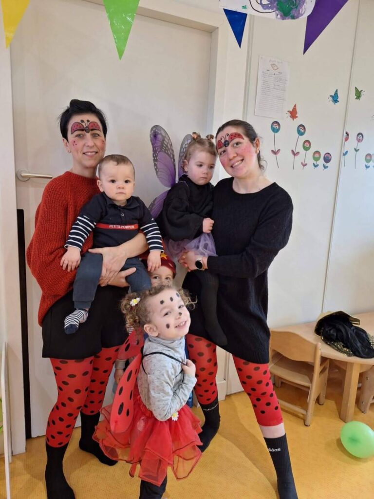 PHOTO D'UNE ÉDUCATRICE ET DES PETITS DE LA CRÈCHE DES MINIS DÉGUISÉS POUR LE CARNAVAL