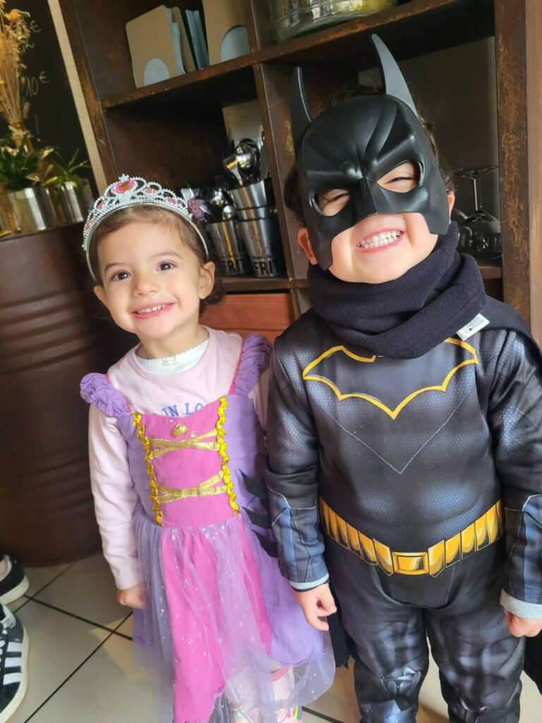 PHOTO D'UNE PETITE FILLE DÉGUISÉE EN PRINCESSE ET D'UN PETIT GARÇON DÉGUISÉ EN BATMAN