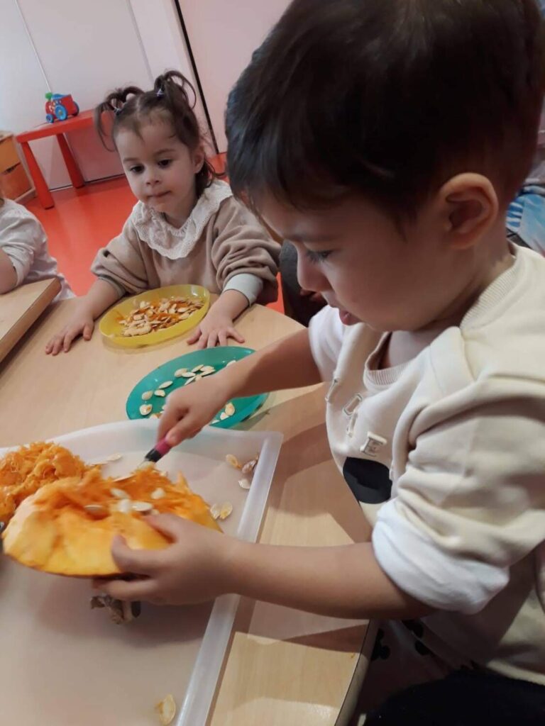 PHOTO D'UN PETIT GARÇON ENTRAIN DE PRÉPARER UNE CITROUILLE POUR HALLOWEEN