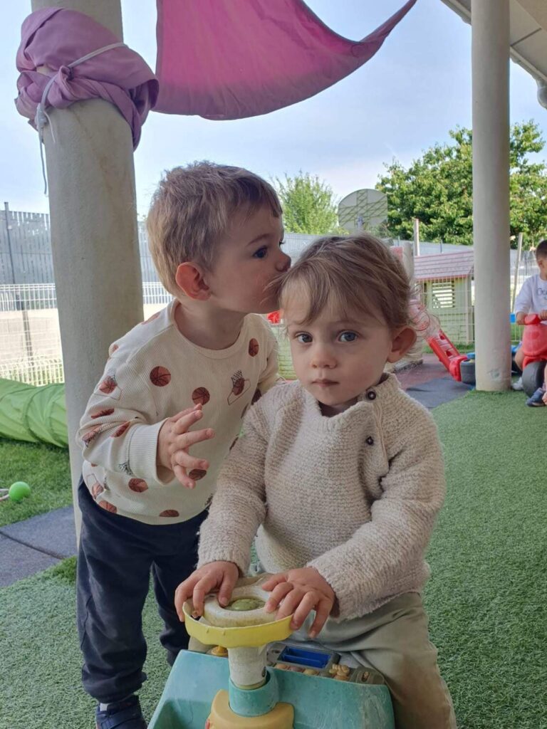 PHOTO D'UN PETIT GARÇON ENTRAIN DE FAIRE UN BISOU SUR LA TÊTE D'UN COPAIN
