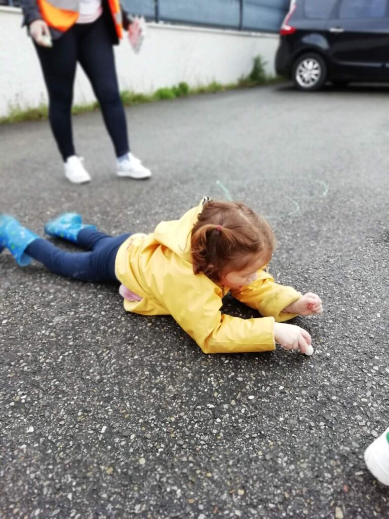 photo des enfants de la crèche des minis entrain de faire des dessins à la craie