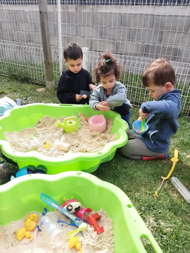 PHOTO DES PETITS ENFANTS DE LA CRÈCHE DES MINIS ENTRAIN DE JOUER DANS LE BAC À SABLE
