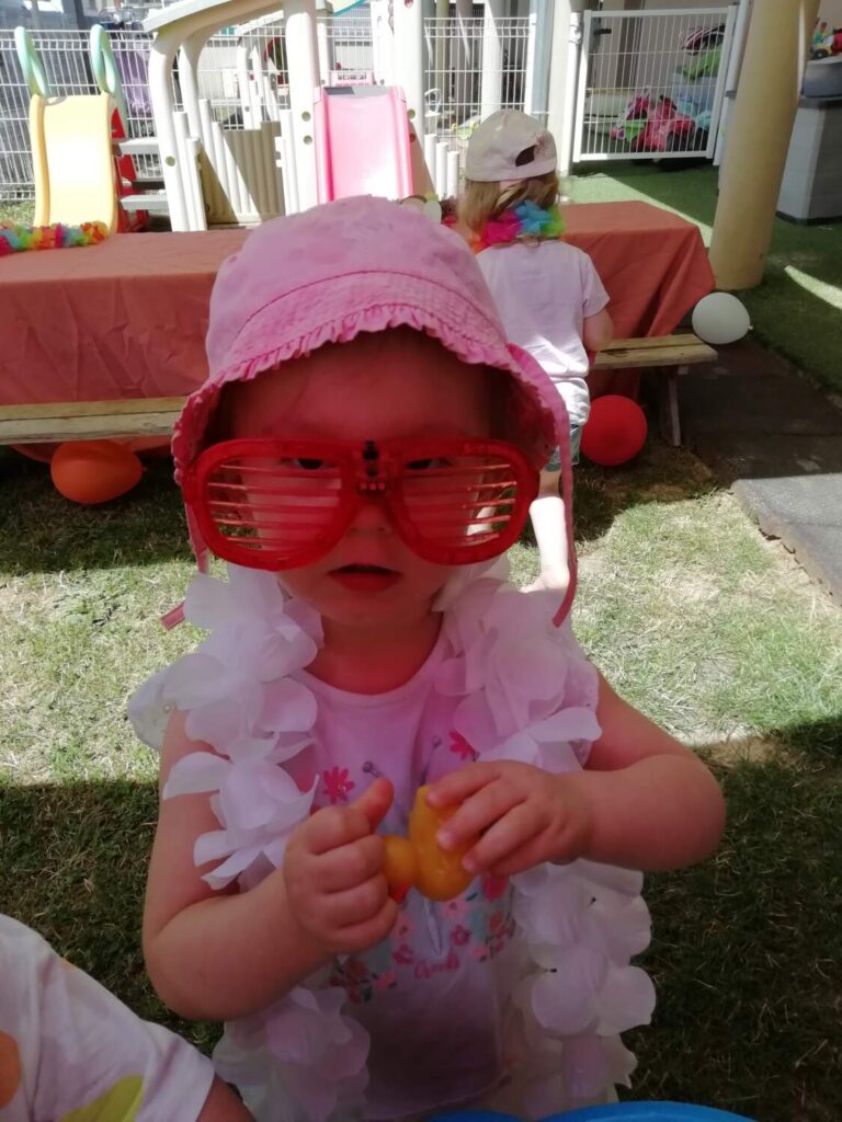 PHOTO D'UNE PETITE FILLE DÉGUISÉE AVEC DES GROSSES LUNETTES ROSES