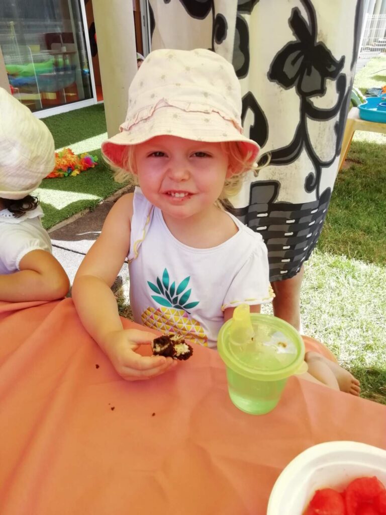 PHOTO D'UNE PETITE FILLE ENTRAIN DE MANGER UN GÂTEAU