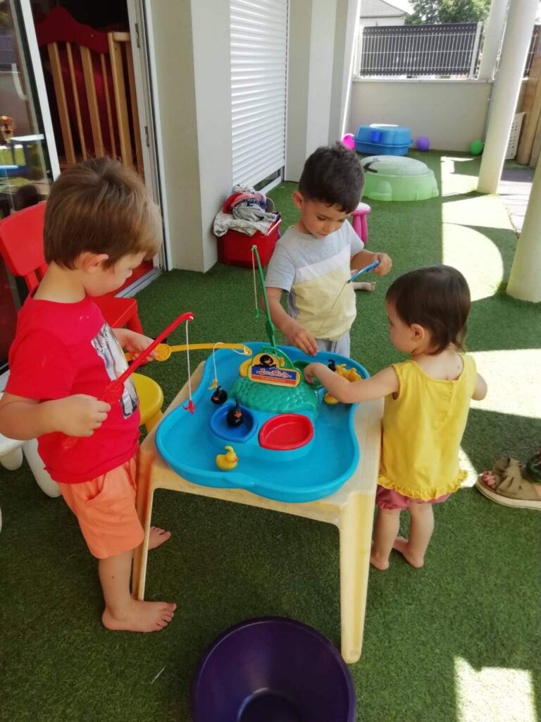 PHOTO DES ENFANTS DE LA CRÈCHE DES MINIS ENTRAIN DE JOUER DANS LE JARDIN