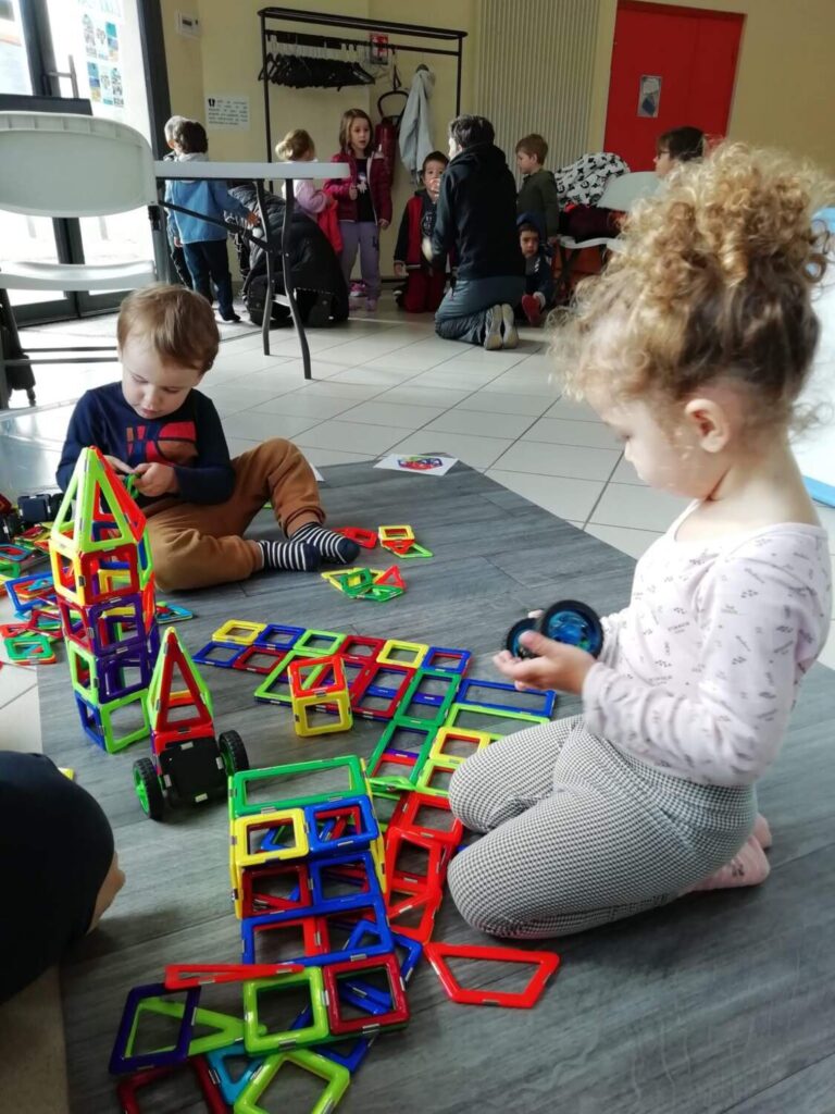 PHOTO DES ENFANTS DE LA CRÈCHE DES MINIS ENTRAIN DE JOUER AVEC DES JEUX AIMANTÉS