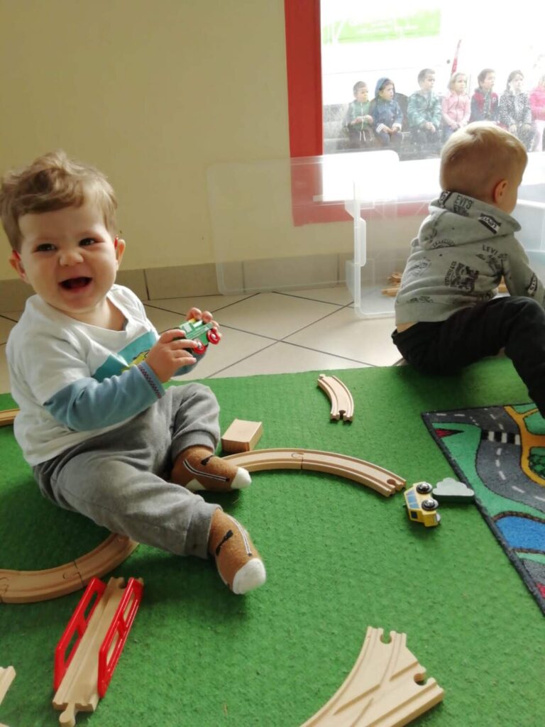PHOTO D'UN PETIT GARÇON ENTRAIN DE JOUER AVEC UN TRAIN EN BOIS