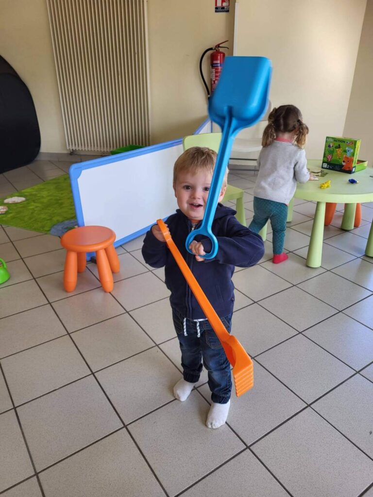 PHOTO D'UN PETIT GARÇON ENTRAIN DE JOUER AVEC DES JOUETS EN PLASTIQUE