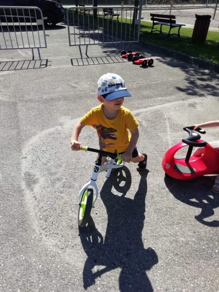 PHOTO D'UN PETIT GARÇON ENTRAIN DE FAIRE DU VÉLO DANS LA COUR DE LA CRÈCHE DES MINIS