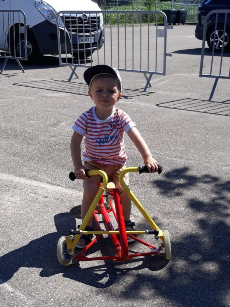 PHOTO D'UN PETIT GARÇON ENTRAIN DE FAIRE DU VÉLO DANS LA COUR DE LA CRÈCHE DES MINIS