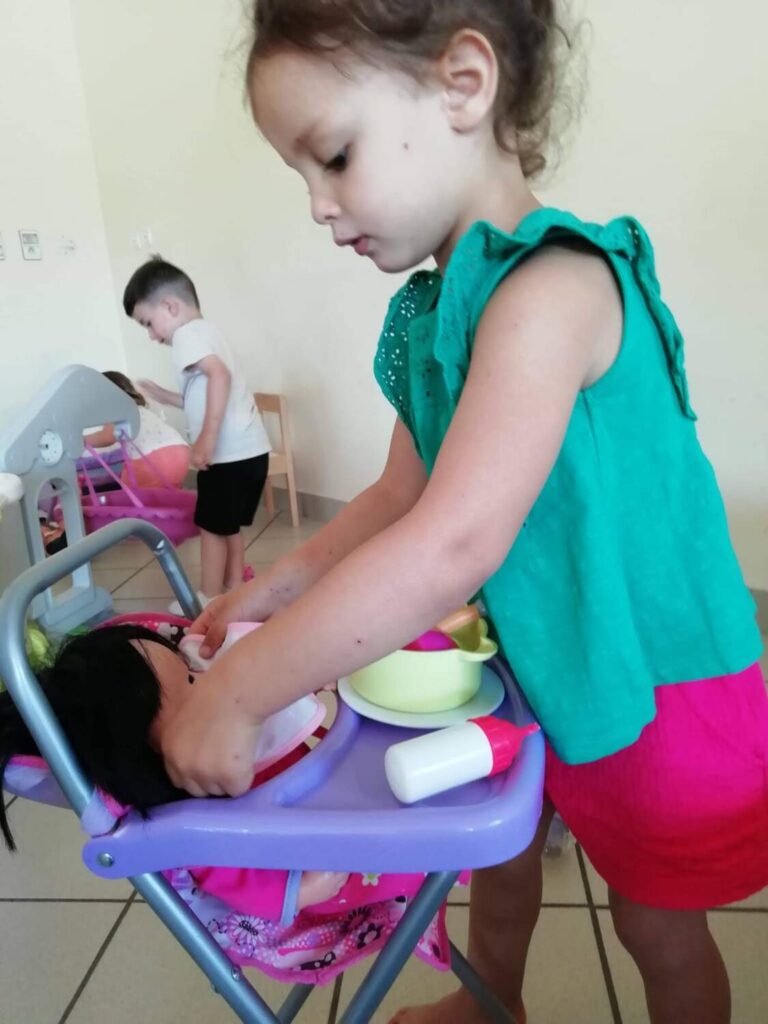 PHOTO D'UNE PETITE FILLE ENTRAIN DE JOUER AVEC UN POUPON