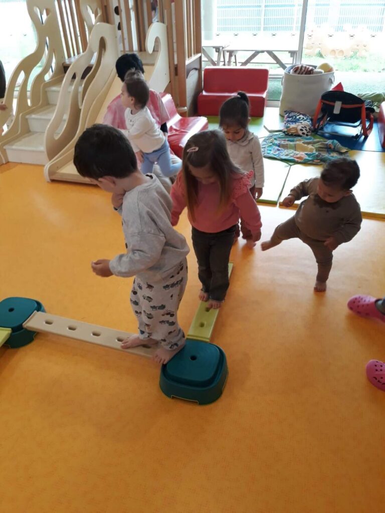 PHOTO DES ENFANTS DE LA CRÈCHE DES MINIS ENTRAIN DE FAIRE UN PARCOURS DE PSYCHOMOTRICITÉ