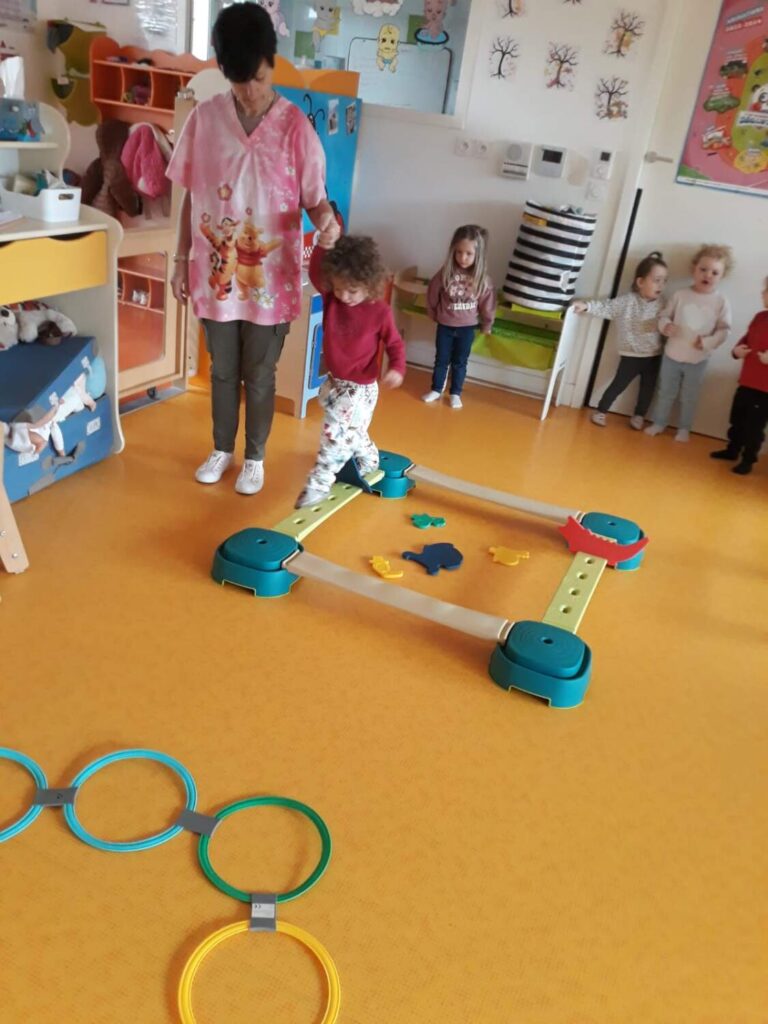 PHOTO DES ENFANTS DE LA CRÈCHE DES MINIS ENTRAIN DE FAIRE UN PARCOURS DE PSYCHOMOTRICITÉ