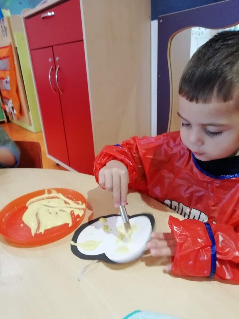 PHOTO D'UN PETIT GARÇON ENTRAIN DE FAIRE DE LA PEINTURE