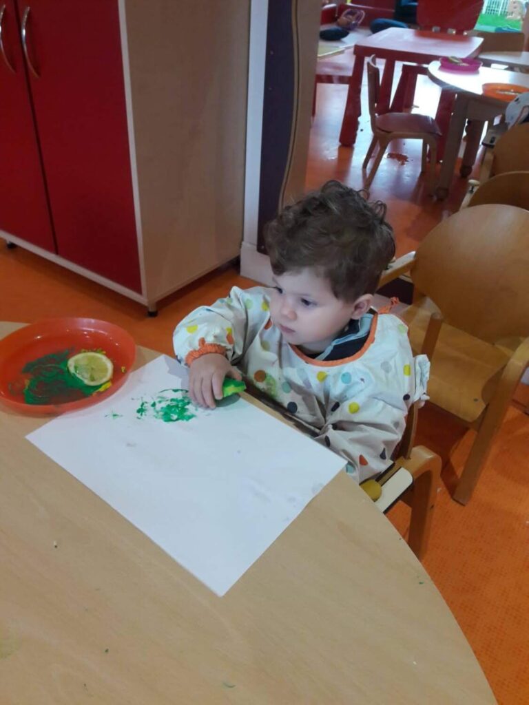PHOTO D'UN PETIT GARÇON ENTRAIN DE FAIRE UN DESSIN AVEC DE LA PEINTURE